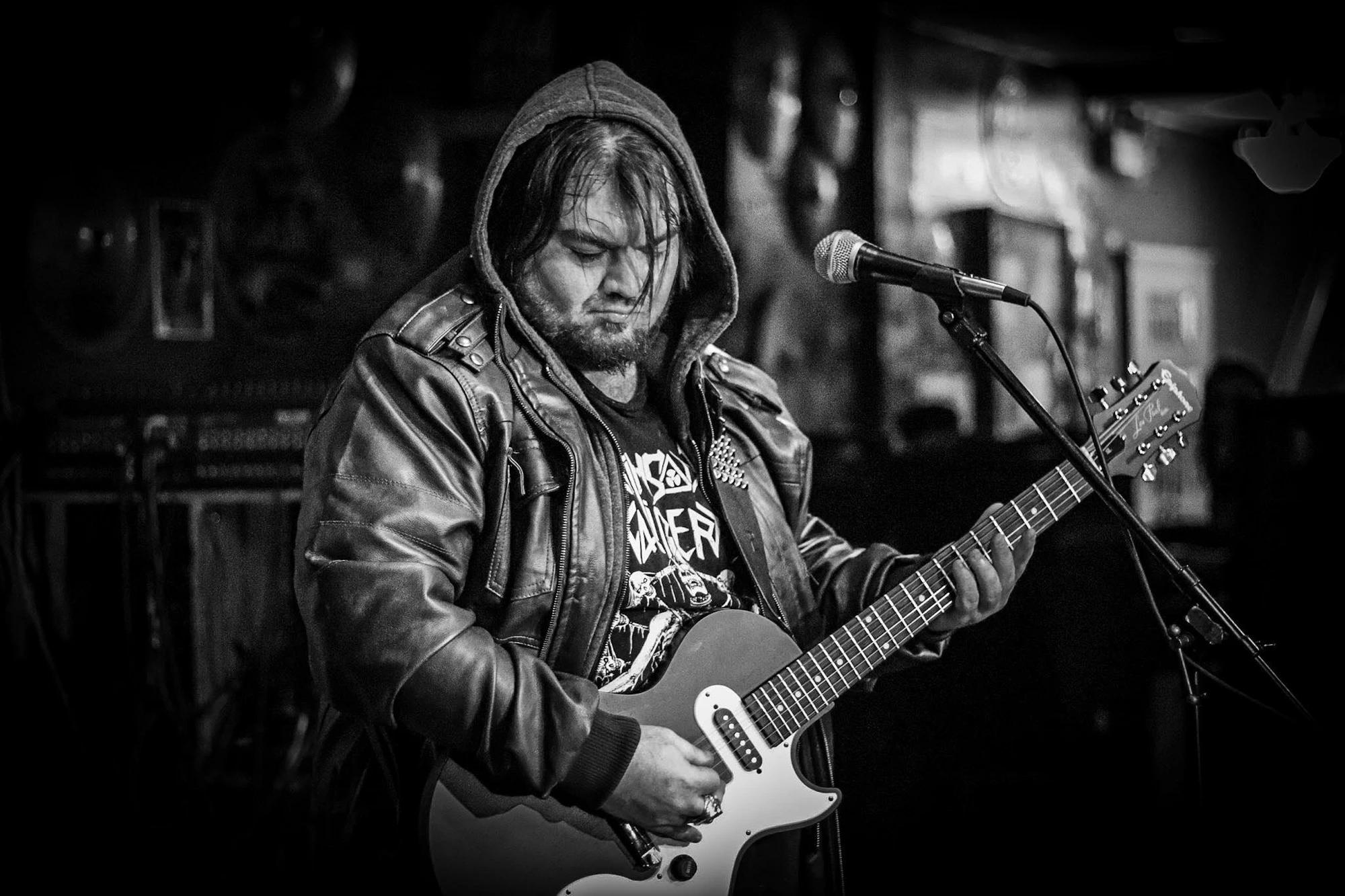 Nox Harmonia on stage, hooded, in front of the microphone